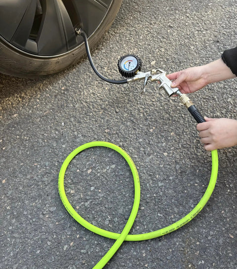 Using Heavy Duty Hybrid Air Hose 3/8 X 10 Ft to inflate a tire, showing kink-free flexibility and industrial fittings.