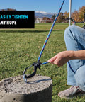 CamJam SlideLock Rope Tightener with Quick Release Lever in use, securing a rope to a concrete block, outdoor setting