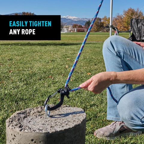 CamJam SlideLock Rope Tightener with Quick Release Lever in use, securing a rope to a concrete block, outdoor setting