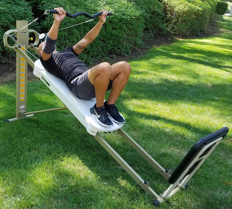 Person using EZ Curl Bar for heavy weight training on Bowflex and home gym cable systems with neutral grip outdoors