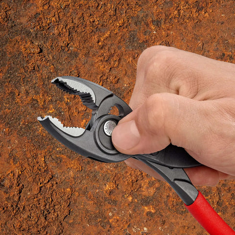 Hand using Slim Front And Side Grip Pliers With Box Joint And Push Button Adjustment For Tight Spots, 200 Mm on rusted surface
