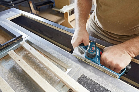 Person using 12V Max EC Brushless Planer Bare Tool With 14,500 RPM For Fast Stock Removal on wooden surface, showing precise shavings.