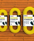 Three yellow outdoor extension cords, 25ft, 50ft, and Heavy Duty 100 Foot 14 3 SJTW with 3 prong ground plug, on wooden surface.