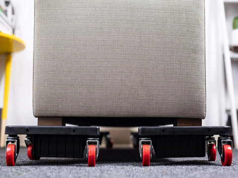 Heavy Duty Furniture Caster Set With 3 Wheel Low Profile Design For Easy Moving under a sofa, showcasing red swivel wheels.