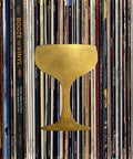 Boozey Beats And Top Shelf Tips For Craft Cocktails with a golden cocktail glass over vintage vinyl records.