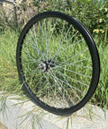 26 Inch Rear Wheel Double Wall Aluminum Beefy Heavy Duty 10G 36 Spokes For MTB Road Cruiser Disc Brake Hub 180mm Sealed Axle 135mm Dropout 22.44 Inch Rim displayed against greenery
