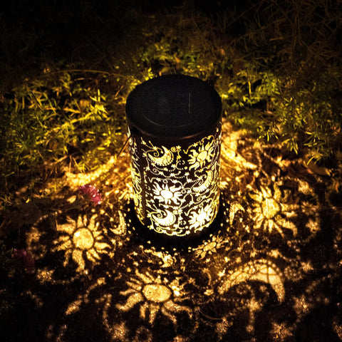 Outdoor Solar Lanterns For Garden Decor, Hanging Metal Sun Moon Star Lights casting glowing patterns on the ground.