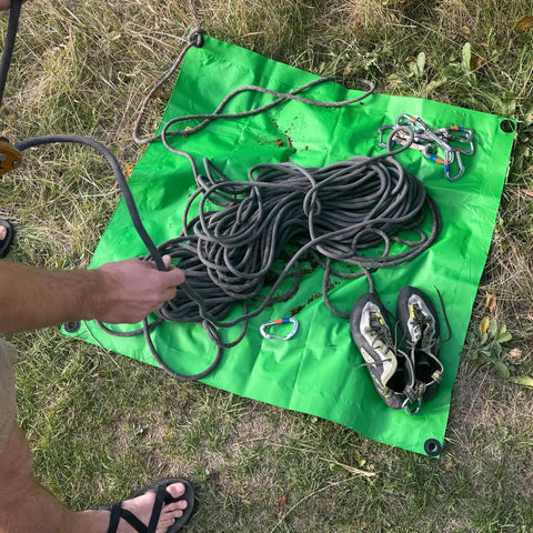 Beefed Up 3x3 Ft Green Heavy Duty Tarp Waterproof UV Resistant PFAS Free Cover laid on grass with climbing gear