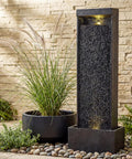 35 Inch Outdoor Water Fountain With Modern Curved Faux Slate Resin Waterfall And 2 Warm LED Lights For Garden Patio Yard Deck Porch Balcony Decor Home Art Water Feature In Black Keeps Your Outdoor Vibe On Point next to potted plant on stone path