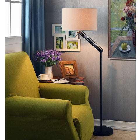 Hydra Adjustable Floor Lamp In Oil Rubbed Bronze Finish With Flexible Arm And Dual Swivel Points beside chair in room