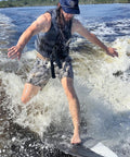 Person wakesurfing on Mondo 5 Foot 2 Inch Wakesurf Board With EVA Padding Thruster Fin Design on a sunny day