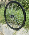 26 Inch Double Wall Aluminum Front Rim Beefy Wheel With 10G 36 Spokes For MTB Road Cruiser Bicycles Disc Brake Compatible 100mm Dropout 145mm Hub Rim Size 22 Inch Up To Two And A Half Inch Tire shown outdoors