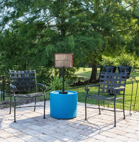 Outdoor Table Lamp With Tropical Bamboo Shade In Oil Rubbed Bronze Highlight Finish Casual Style Patio Light For Deck Or Porch 29 Inch Tall With 14 Inch Shade Diameter On Off Socket Switch on blue table between chairs in lush garden setting.