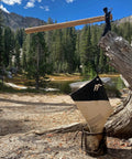 Water Filtration Bag for Bushcraft and Military Use, Second Edition hanging on a branch in forest, rugged survival gear UK