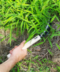 Hand using Go-To 6.7 Inch Japanese Serrated Garden Sickle With Razor Sharp Carbon Steel Blade For Harvesting And Weeding Made In Japan