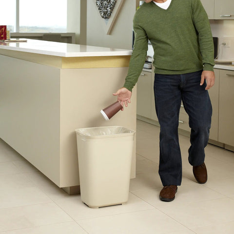 Person using Fire Resistant Wastebasket 40 Qt 10 Gal Beige For Hospitals Schools Hotels And Offices UL Certified Safety Trash Can Durable Resin With Textured Finish Built Tough in kitchen setting.