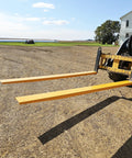Pair of 92-inch forklift pallet fork extensions, 4-inch wide, yellow steel, attached to a forklift.