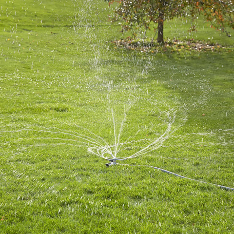Heavy Duty Spinning Sprinkler With Wheeled Base For 360 Degree Coverage in operation on lawn delivering gentle rain-like spray