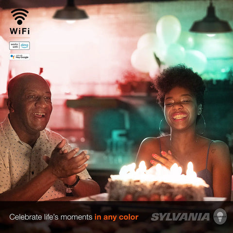 People smiling around a birthday cake under lighting by Smart WiFi LED Light Bulb A19 Millions Of Colors And Tunable White.