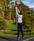 Man shooting basketball with XL Defender Pro Basketball Rebounder Net For Outdoor Driveway Hoops, Quick Setup Easy Fold Design.