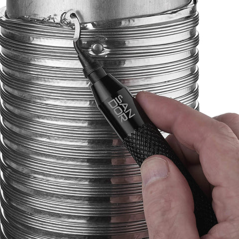 Close-up of a black deburring tool with replaceable blade held by hand against a metal ribbed cylinder.