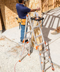 Worker using 375 Pound Rated Ladder Work Platform Accessory with tools on wide secure surface for hands free workspace