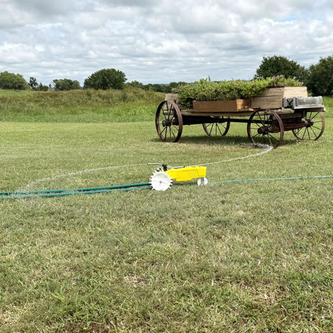 Traveling Sprinkler That Rolls Across Large Lawns Up To 13,500 Sq Ft Cast Iron Outdoor Water Sprinkler in bright yellow on grass