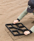 Person using 2 Pack Outdoor Pavement Molds For DIY Cement Stepping Stones Walkway Maker on sandy ground