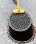 Kickass Three Magnet Manhole Lid Lifter Pulls Up To Two Hundred Fifty Pounds No Sweat Featuring Boss Level Neodymium Magnets And Ergonomic Handles For Fast Pro Worker Repairs Made In Usa lifting a manhole cover with a secure grip.