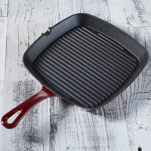 Chef's Classic Enameled Cast Iron Nine And A Quarter Inch Square Grill Pan In Cardinal Red on wood surface