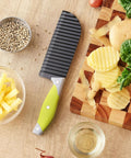 VRUIFA French Fry Cutter with lime-green handle and ridged black blade on wooden board
