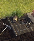 Heavy Duty Woven Weed Control Fabric 6 by 33 Feet Black Ground Cover Membrane on garden lawn for weed suppression.