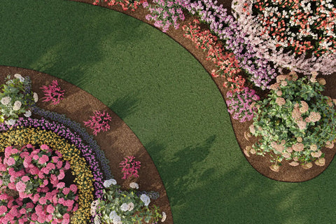 Aerial view of landscaped garden with curved flower beds, showcasing neat borders for an installed 4 Inch Composite Landscape Edging Kit.