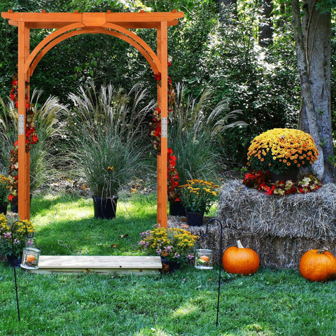 85 Inch Wooden Garden Arch Trellis For Climbing Plants in a lush garden with pumpkins and hay, natural brown wood finish