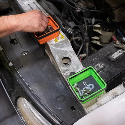 Foldable Magnetic Parts Tray Set For Mechanics showing orange and green trays with fasteners on a car engine