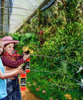 Two children using Realistic Nine Inch Fire Extinguisher Squirter Toy Pack Of Two Pump Action Water Blaster outdoors.