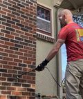 A worker applying The Real Deal Deep Penetrating Siloxane Masonry Sealer For Brick Concrete And Stucco to a brick wall.