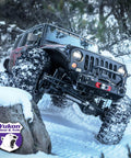 Off-road vehicle climbing snowy terrain with Yukon Gear & Axle branding on windshield