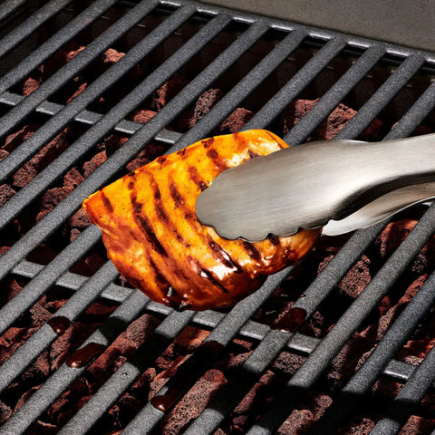 Outdoor Grilling Turner And Tongs Set With Heavy Duty Stainless Steel Construction holding grilled meat on barbecue