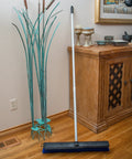 No Nonsense Commercial Floor Sweep With Integrated Squeegee Includes Sixty Inch Three Piece Aluminum Handle And 24 Inch Broom Head on wooden floor.
