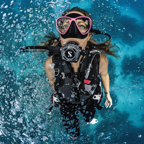 Diver underwater wearing MK25 EVO A700 Carbon BT Diver Regulator System DIN, showcasing rugged durability and sleek high-tech look.