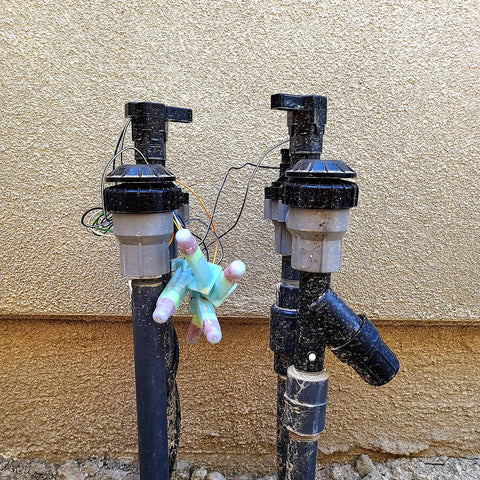 Waterproof Direct Burial Wire Splice Kit For 18 To 10 AWG Cables 600V Max 25 Pack in use with outdoor irrigation system piping.