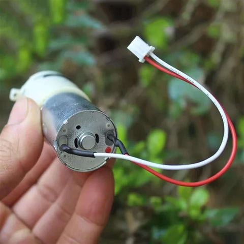 Close-up of Compact DC 6V 9V 12V Micro 370 Motor Self Priming Diaphragm Water Pump in hand, showing motor connections and wiring