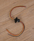 High Current Slip Ring Rotating Connector With 3 Wires 10A 22Mm Diameter, shown with colored wires on a wooden surface