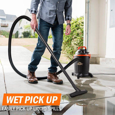 Man using Powerful 2 HP Wet Dry Vacuum With 4 Gallon Tank and Nozzles on wet floor in garage