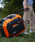 Person transporting 6800-Watt Dual Fuel RV-Ready Inverter Generator With Electric Start, Portable Backup for RVs and EVs, on grass