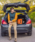 Man sitting on car trunk with 2300W Gasoline Inverter Generator With Pure Sine Wave Output, Portable Power Station visible inside.