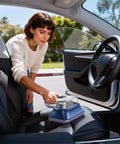 Woman using All-In-One Powerful Handheld Mattress Vacuum With Deep Vibration, UV-C Light, LED Display, And HEPA Filter in a car