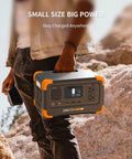 Person holding Go To Portable Power Station 288Wh LiFePO4 Battery With 600W Pure Sine Wave Inverter, rugged outdoor setting