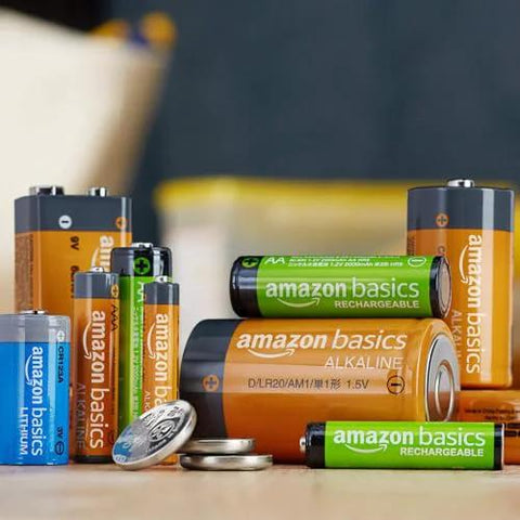 Various Amazon Basics batteries including AA Rechargeable NiMH Batteries 2000 mAh Low Self Discharge 1000 Recharges 8 Pack displayed on a table.
